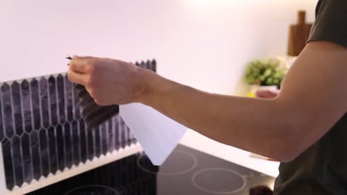 Man Applies Peel and Stick Tile to Kitchen Wall