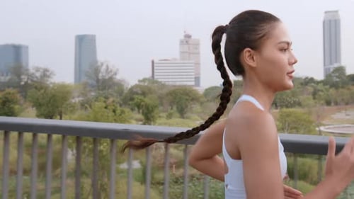Young fitness woman in sportswear jogging in city park