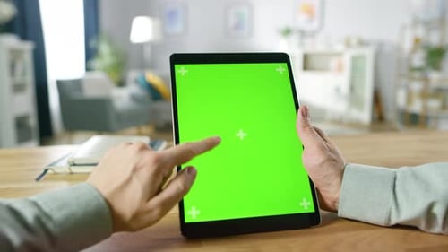 Close-up of Man Using Hand Gestures on Green Mock-up Screen Digital Tablet Computer in Portrait Mod