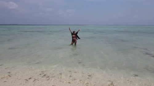 Aerial view of an Asian woman wearing bikini having a fun holiday at the beach in Karimunjawa