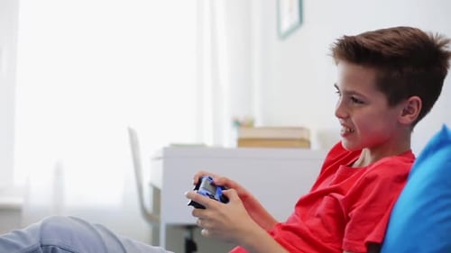 Teenage Boy Plays Video Game on Sofa