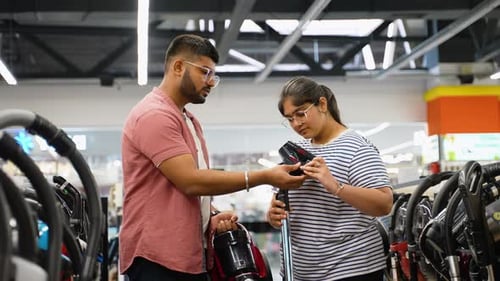 Indian Couple Buying New Vacuum Cleaner at Tech Store for New Home