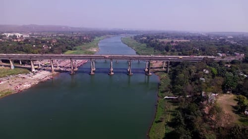 aerial view of Narmada River with Tilwara bridge and greenery at day time, push in, pan shot, drone