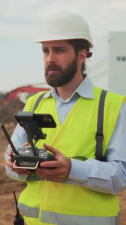 Operator Managing Drone During Construction Supervisor Controlling Drone While Coordinating