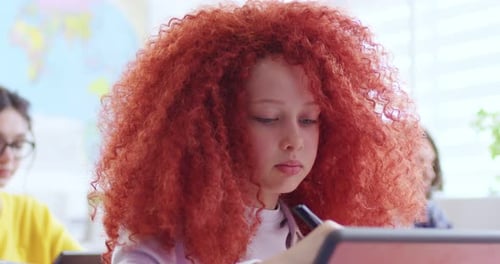 Concentrated Pretty Girl with Stylus Pen Writing on Modern Tablet Close Up of Focused Red Haired