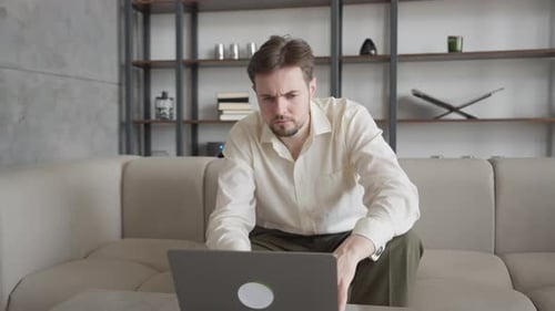 Young Man Working on Laptop at Home