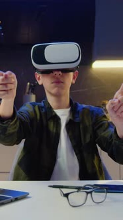 Teenager Using VR Headset at Desk in Dark Room