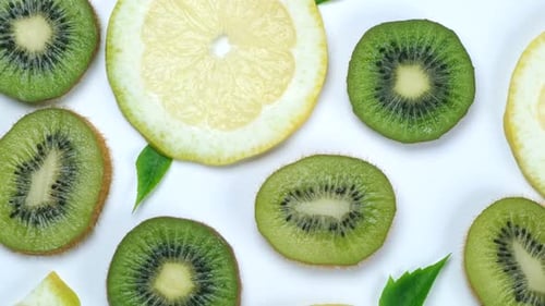 Rotating Food Trendy Background of Kiwi and Lemon or Lime Slices on White Background Healthy Eating