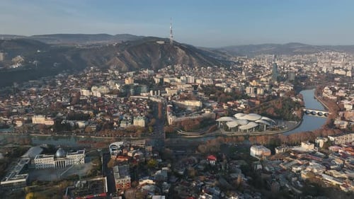 Aerial panoramic view of Tbilisi, Georgia, with the Kura River, city center, and Mount Mtatsminda