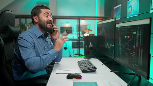 Man Talks on Phone at Modern Computer Workstation