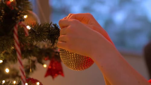 Decorating Christmas Tree with Golden Bauble Ornament