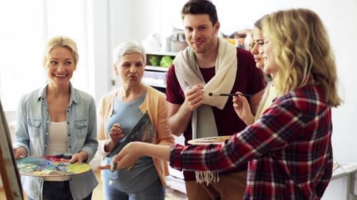 Art Class Students Gather Around an Easel Indoors