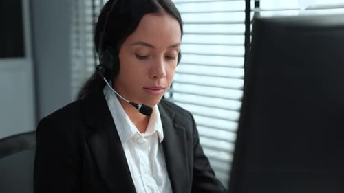 Professional Woman Working at Computer Wearing Headset