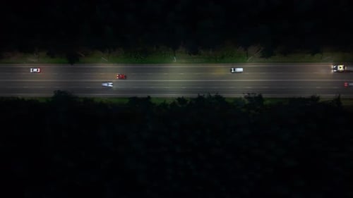 Cars Travel Along the Highway at Night Under a Clear Sky