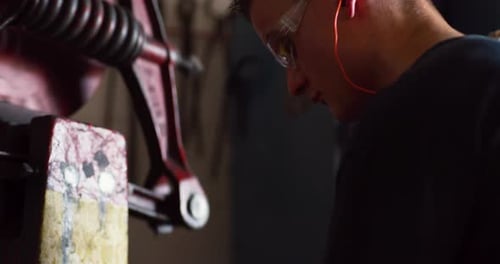 Professional metalsmith forging hot metal in blacksmith workshop interior