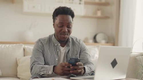 Cheerful Young Black Man Surfing Internet By Smartphone Amazing and Smiling Portrait of Internet