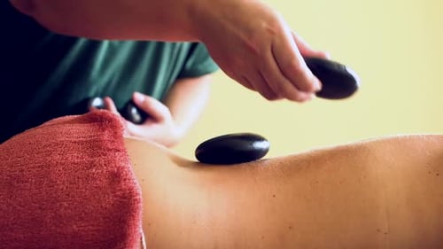 Woman Receives Relaxing Hot Stone Back Massage