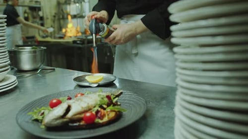 Restaurant Chef Broiling Lemon with Blow Torch before Serving Dish