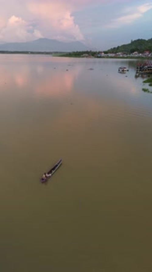 Drone vertical filmé par un pêcheur sur son bateau dans le lac