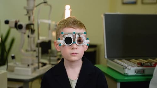 Child Patient Undergoing Eyesight Examination with Trial Frame By Optometrist