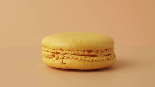 Close Up of Yellow Macaron on Peach Background