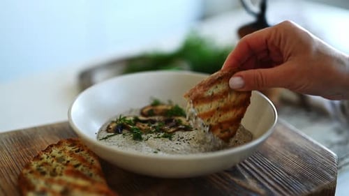 Dipping Bread into Mushroom Soup with Dill