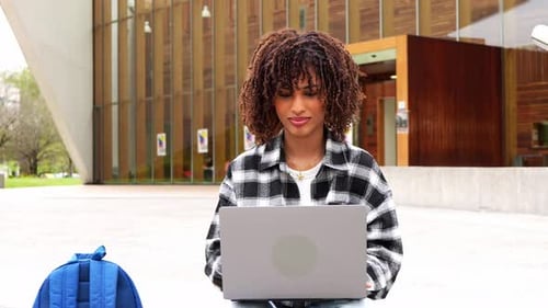 Young African American College Student Using Laptop on Campus