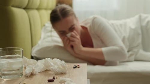 Femme caucasienne éternuant, écoulement nasal, inconfort, éternuement avec un mouchoir à la maison, fille frustrée