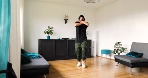 Man Working Out at Home Doing Jumping Jacks