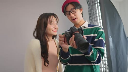 Asian beautiful woman model and cameraman working in photography studio.