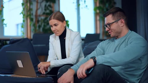 Colleagues Working Together on a Laptop in Office
