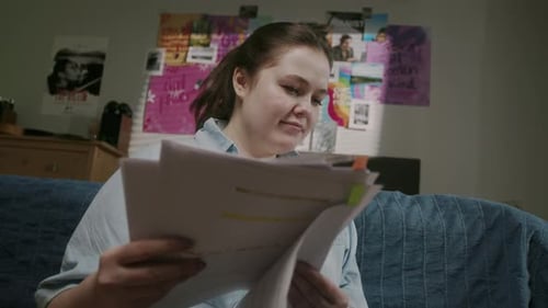 Young Woman Reads Papers at Home