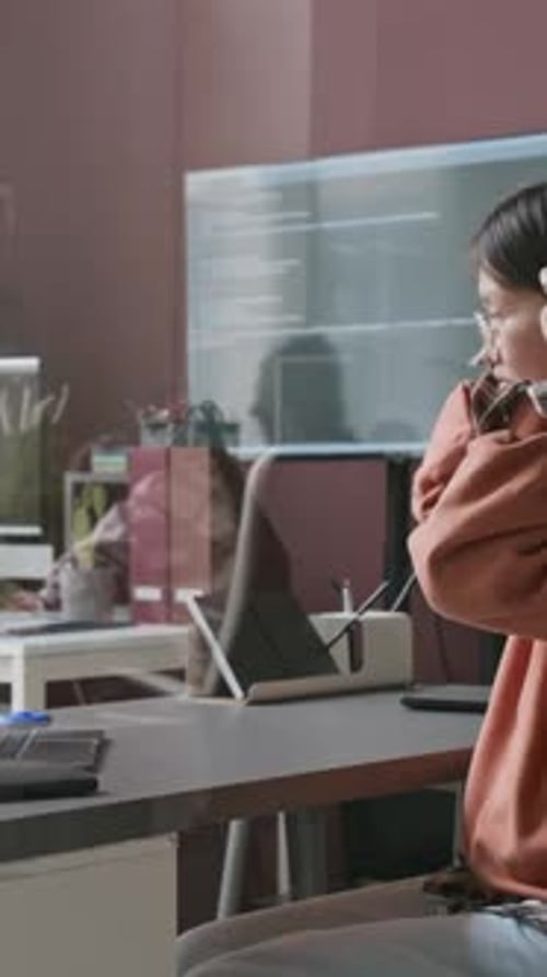 Asian Female Programmer Enjoying Music while Working on Project