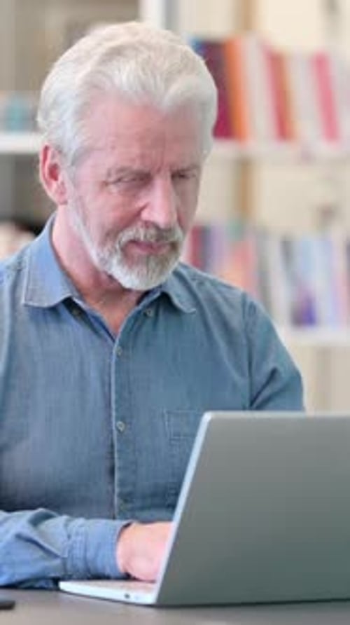 Senior Man Working on Laptop and Smiling