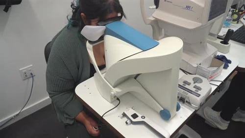 Woman Checking Her Eyes Through Automatic Perimeter Equipment At Optometrist Clinic. - closeup shot
