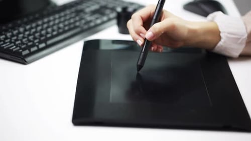 Creative businesswoman drawing on pen tablet at her office workplace