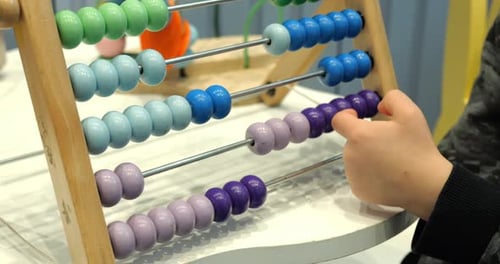 Un estudiante de Little Kid reemplaza los bloques del ábaco en el preescolar