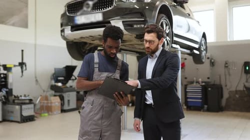Mechanic Discussing Car Repair with Customer in Auto Shop