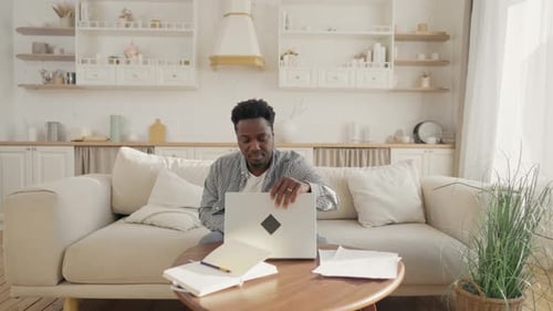 Man Working on Laptop in Bright Living Room