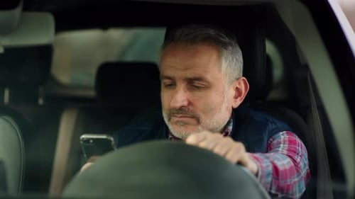 Man in Car Using Smartphone Close Up