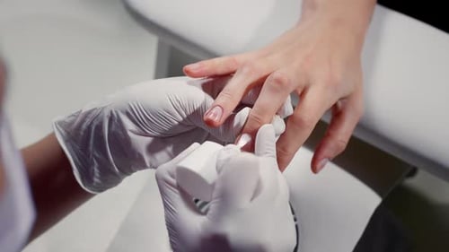Nail Technician Applying Clear Polish in Salon