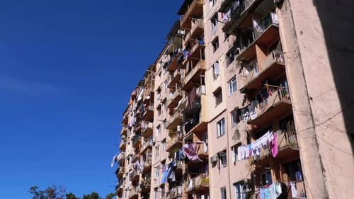 Drying Clothes on a Clothesline Between the Balconies on the Highrise Old House in a Poor Area of