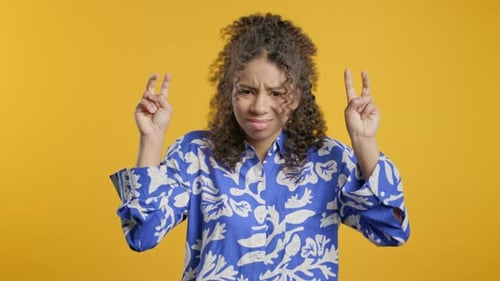 Woman Poses Peace Sign in Studio Setting