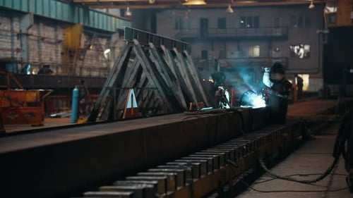 Welder Sparks Flying at Industrial Plant at Night