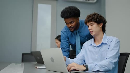 Caucasian and african american men with asian woman working together on a laptop in office