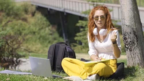 University student studying in the park solving questions.