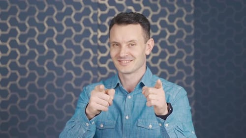 Man Smiling and Pointing at the Viewer