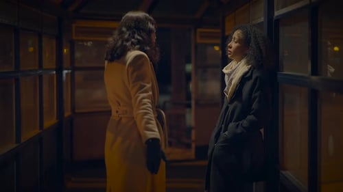 Women in Coats Talking in an Urban Walkway