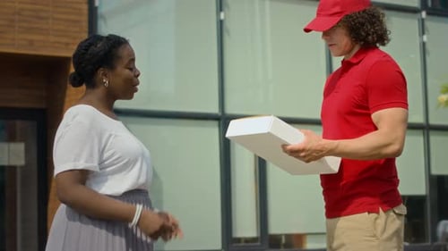 Courier Giving Parcel to Female Client Signing Form Outdoors