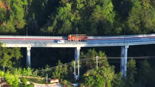 Telephoto drone shot of a truck on highway bridge, in rural China, sunny day